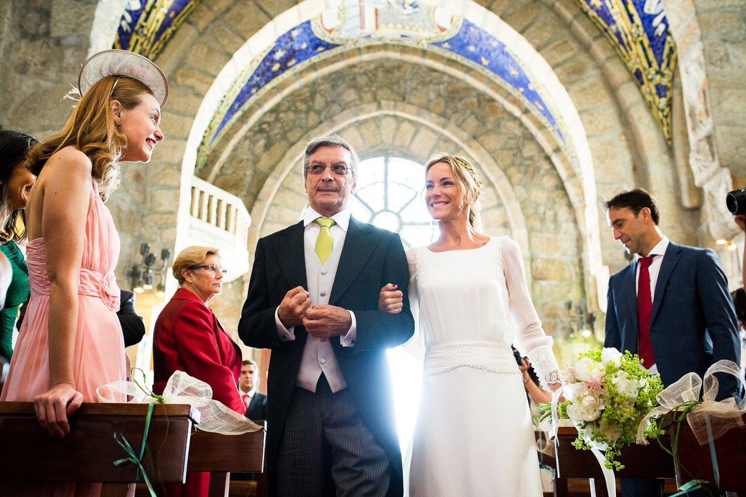 Fotografía de boda novia con el padrino e invitados en la iglesia
