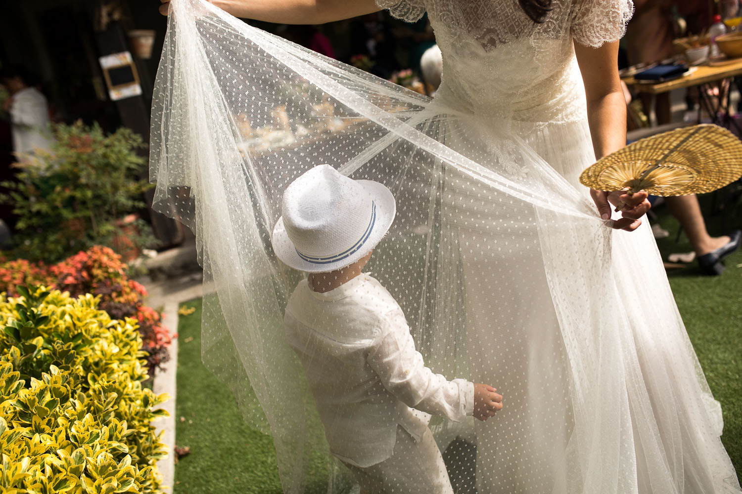 Fotografia de boda niño jugando con el velo de la novia